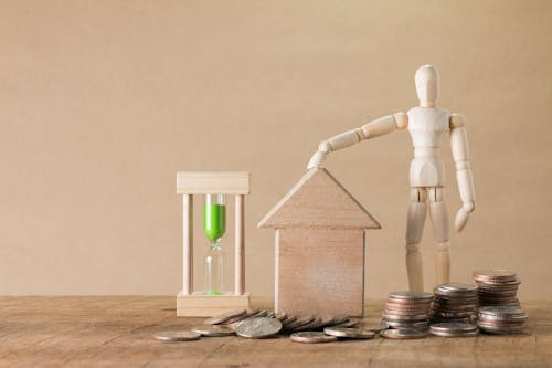 Texas home equity loan concept showing a house model, coins, and an hourglass representing property value, lending, and financial planning.